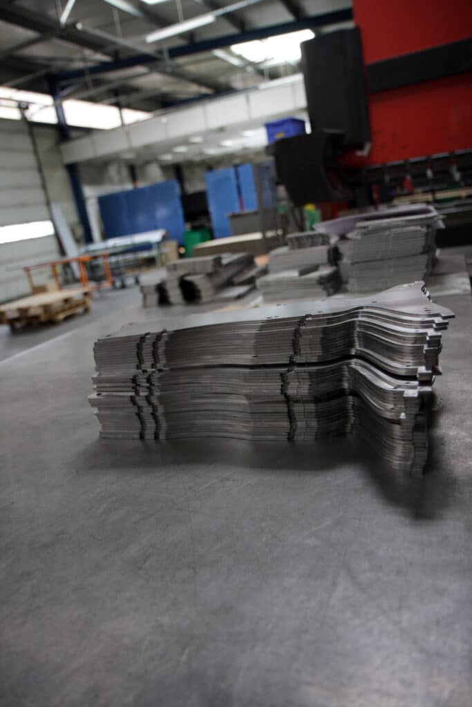 Empilage de pièces métalliques découpées avec précision dans un atelier de tôlerie industrielle.